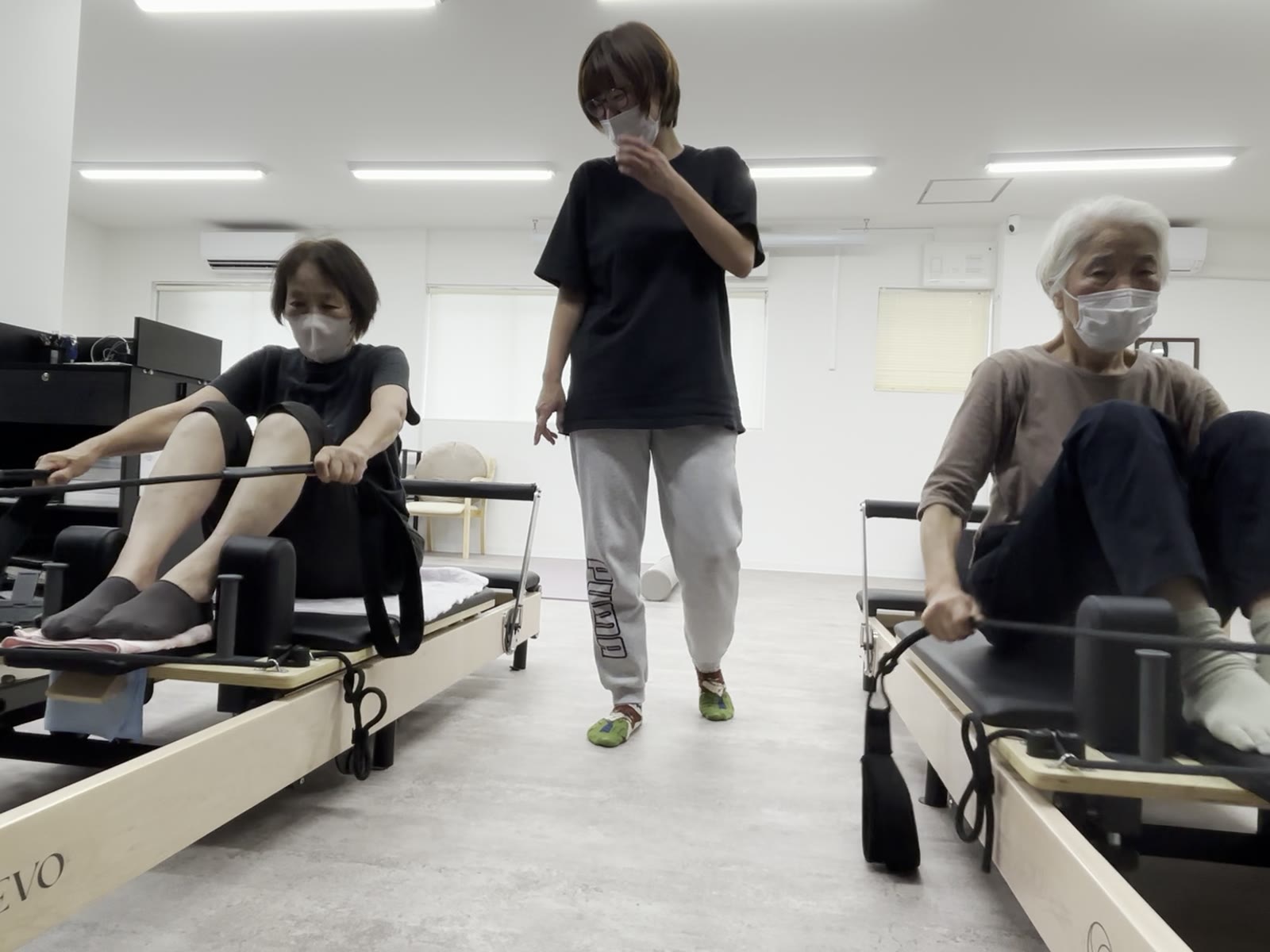 戸畑区天籟寺の Move fit 戸畑(月会費の会員は女性限定)。2人の女性がピラティスマシンで運動し、そのあいだを女性トレーナーが見て回っている